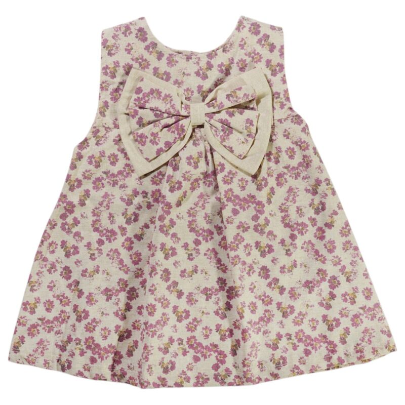 Ανάλαφρο φορεματάκι Zeo Kids «Lilac» με ρομαντικό all-over τύπωμα λιλά λουλουδιών και εντυπωσιακό φιόγκο στο μπροστινό μέρος.